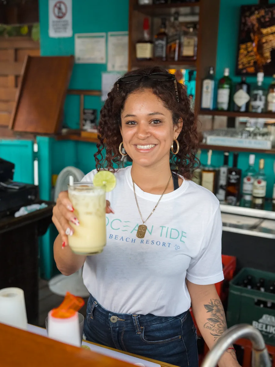Gabby, bartender at the Lazy Pelican, holding out a freshly blended cocktail