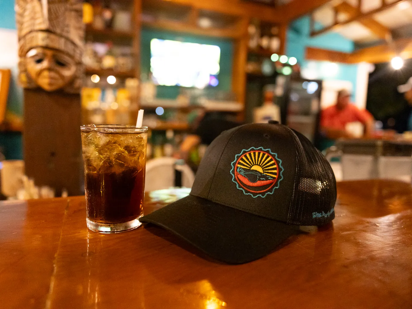 Lazy Pelican cap and a rum and coke on the bar at night